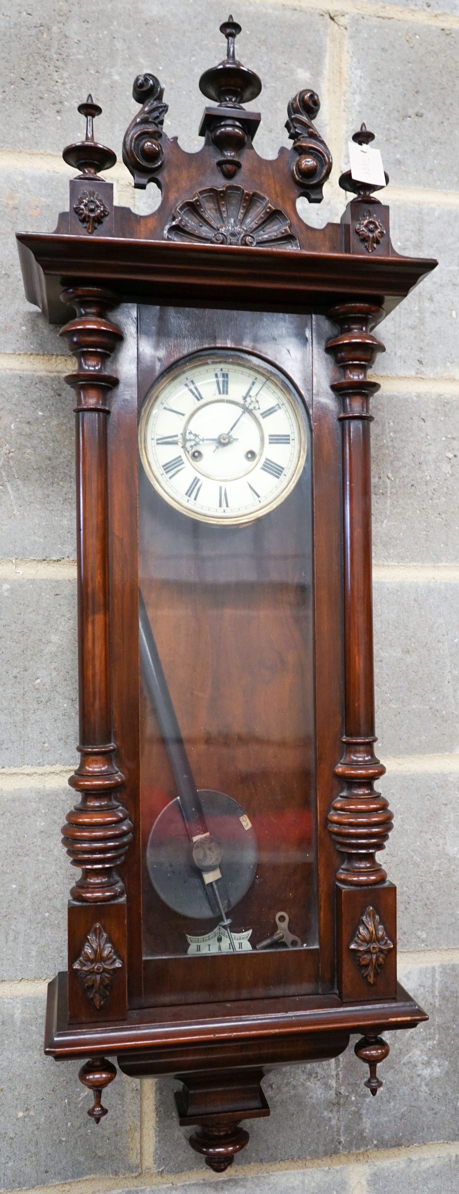 A Vienna style wall clock, having enamelled Roman dial and striking movement in glazed mahogany case, height 110cm